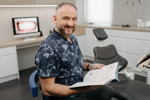 smiling dentist holding a book